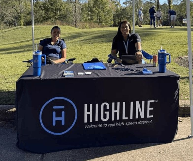 female Highline employees sitting at booth outside