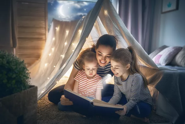 Mom and kids reading in a tent