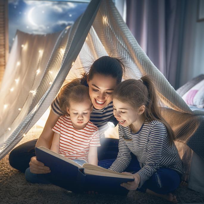 Mom and kids reading in a tent