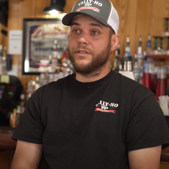 Man seated at wooden bar counter