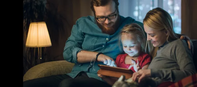 Photo of family looking at tablet together