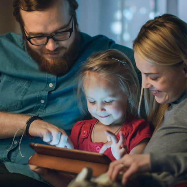 Photo of family looking at tablet together