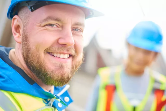 Photo of worker in hardhat smiling toward camera