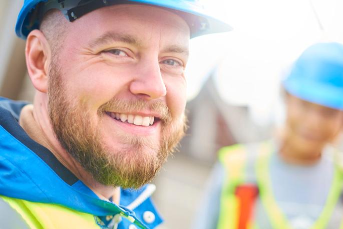 Photo of worker in hardhat smiling toward camera